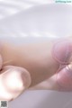 A close up of a woman's legs in a pink bra.