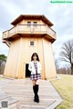 A woman standing in front of a wooden building.