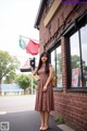 A woman standing in front of a brick building.