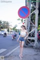 A woman standing in front of a no parking sign.