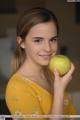 A woman holding a green apple in her hand.