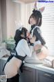 A couple of women in bunny costumes sitting on a kitchen counter.