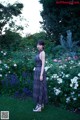 A woman standing in the middle of a lush green field.