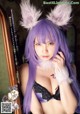 A woman with long purple hair wearing bunny ears.