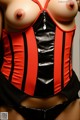 A woman wearing a red and black corset.